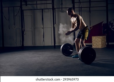 Athlete motivates screaming before barbells exercise at gym