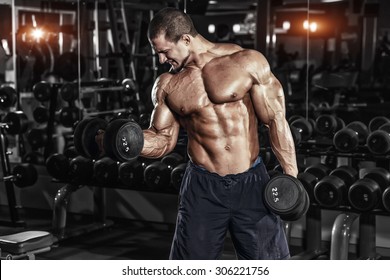 Athlete Muscular Bodybuilder In The Gym Training Biceps With Dumbbell