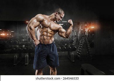 Athlete muscular bodybuilder man demonstrates his muscles in the gym - Powered by Shutterstock