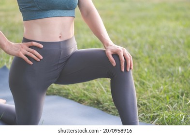 An athlete in nature is engaged in stretching. Yoga classes. Part of the body of a female athlete. A woman stretches her legs before training.