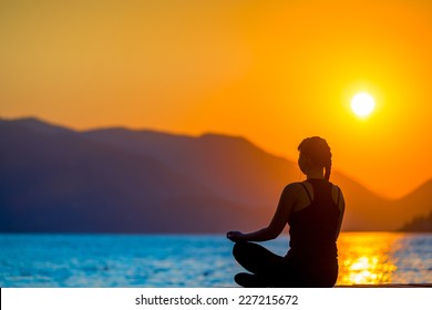 athlete on the background of mountains and rising sun relaxes