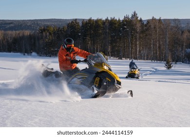 Athlete on a snowmobile moving in the winter forest in the mountains of the Southern Urals.