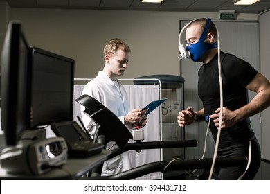 Athlete in oxygen mask running on treadmill and medic in white uniform