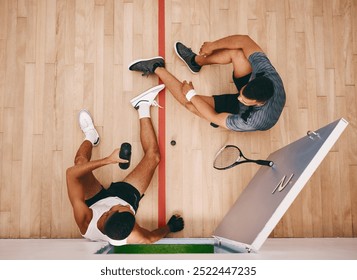 Athlete, people and relax with racket on court from squash competition, fitness break and sports burnout. Above, men and equipment for challenge, hydrate and professional game of match performance - Powered by Shutterstock