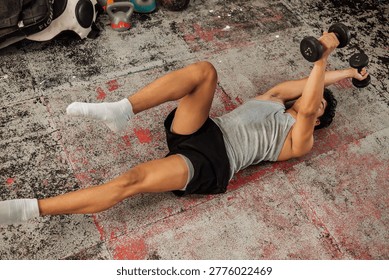 Athlete performs weighted dead bug using dumbbells, enhancing core strength, coordination, and stability during advanced functional training on gym floor.