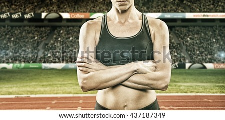 Athlete posing with arms crossed against view of a stadium