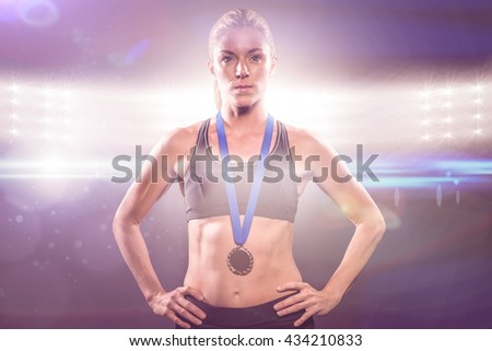 Athlete posing with gold medal around his neck against spotlights