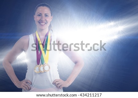 Athlete posing with gold medals around his neck against spotlights