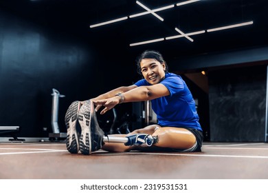 Athlete with prosthetic leg doing warm up exercise on GYM. Woman wearing prosthetic equipment for jogging at fitness Center. Female with prosthesis of leg. - Powered by Shutterstock