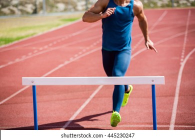 Athlete Ready To Jump A Hurdle On Running Track