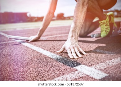 Athlete Ready To Start The Relay Race On Running Track