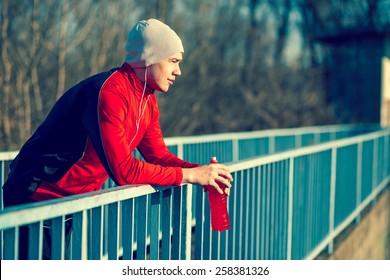 Athlete Relaxing After An Intense Workout, Holding A Bottle Of An Energy Drink