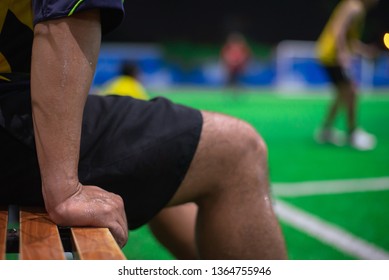 Athlete Resting On Bench In  The Socer Field At Night After Playing Football.