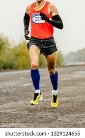 Athlete Runner In Compression Socks And Arm Sleeves Runnning Marathon