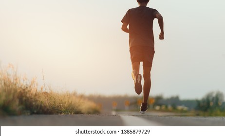 Athlete Runner Feet Running On Road, Jogging Concept At Outdoors. Man Running For Exercise.