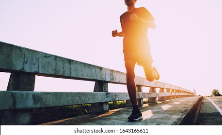 Athlete runner feet running on road, Jogging at outdoors. Man running for exercise.Sports and healthy lifestyle concept.