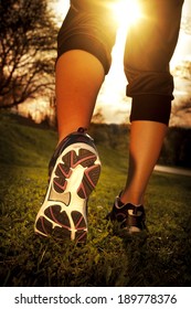 Athlete runner feet running on grass closeup on shoe. Woman fitness sunrise jog workout wellness concept. - Shutterstock ID 189778376