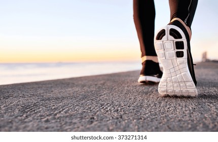 Athlete runner feet running on treadmill closeup on shoe. Jogger fitness shoe in the background and open space around him. Runner jogging training workout exercising power walking outdoors in city. - Shutterstock ID 373271314