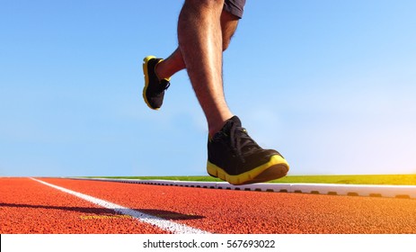 Athlete Runner Feet Running On Running Track. Sport Background