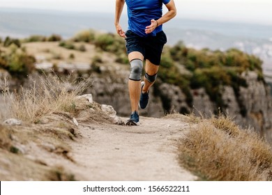 Athlete Runner Knee Injury Run In Knee Pads On Mountain Trail