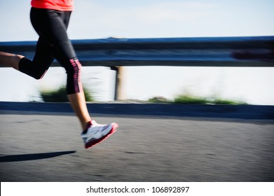 Athlete Runner Motion Blur Running On Road Focus On Shoe. Woman Speed Sprint Fitness Training.