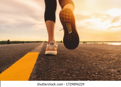 Athlete running on the road trail in sunset training for marathon and fitness. motion blur of woman exercising outdoors - Shutterstock ID 1729896229