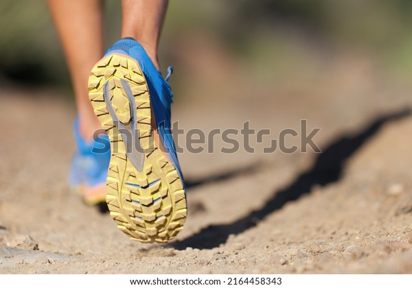 Athlete running sport feet on trail, selective\
focus on sole.Training workout on off road trail track design in\
advertising poster\
style
