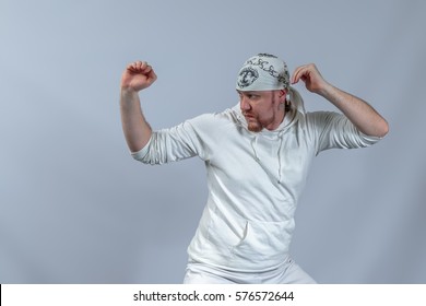 The Athlete In A Suit For Practicing Capoeira Shows Methods Of Struggle, A Light Blue Background