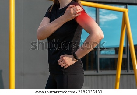 Athlete touching painful shoulder with red point during outdoor training. Dislocation, arthritis, fracture, rotator cuff strain consequences. Health problems in sport concept. High quality photo