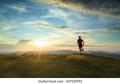 Athlete trail running in Massif du Vercors during sunset. Shallow D.O.F. and with motion blur.