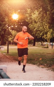 Athlete using a smartwatch while running in nature Healthy lifestyle. 
