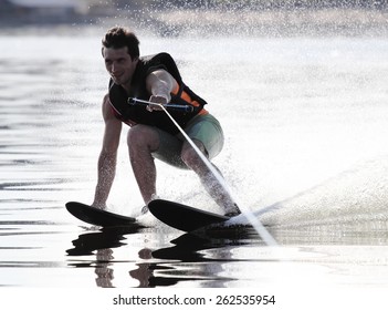 Athlete water skiing and have fun. Summer by the sea.A water skier in his 60's preforming water skiing sport on a lake.