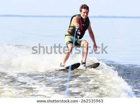 Athlete water skiing and have fun. Summer by the sea.A water skier in his 60's preforming water skiing sport on a lake.