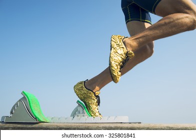 Athlete Wearing Gold Running Shoes Takes Off In A Blur From From The Race Track Starting Blocks 