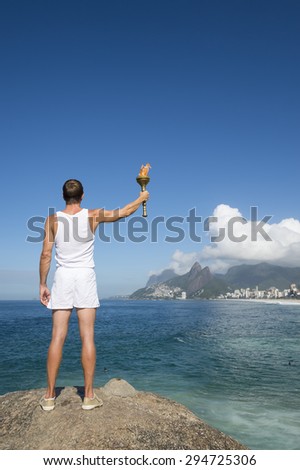Athlete in white uniform standing with sport torch above Rio de Janeiro Brazil skyline at Ipanema Beach