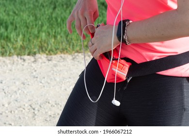 Athlete Woman Closing The Zipper Of Her Pink Fanny Pack.