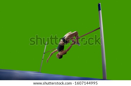 Athlete woman doing a high jump on green screen background.