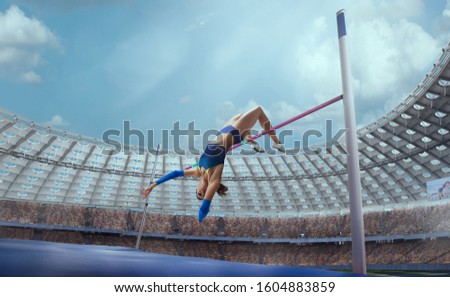 Athlete woman makes a high jump at the sports competition.