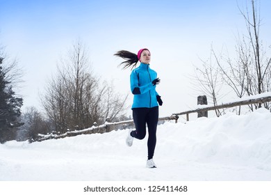 Athlete Woman Is Running During Winter Training Outside In Cold Snow Weather.