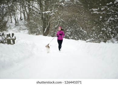 Athlete Woman Is Running During Winter Training Outside In Cold Snow Weather.