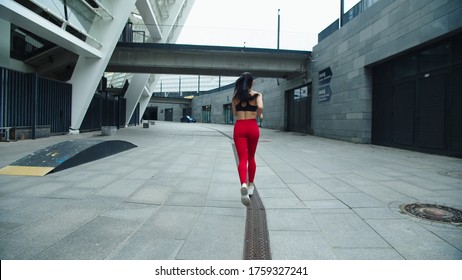 Athlete Woman Running Outdoor In Slow Motion. Back View Runner Girl Training Run Exercise On Urban Street. Sexy Woman Jogging On Street Background. Female Runner Running Outdoor