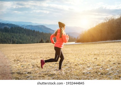 Athlete woman runs in the spring forest. Young female runner jogging exercise outdoors in the morning. Workout for marathon and fitness.