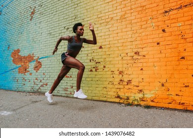 Athlete woman training in the morning at sunrise in New york city, Brooklyn in the background. urban runner making run preparation