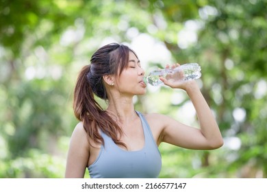 Athlete young beautiful woman drinking water from a plastic bottle at summer green park, Sport woman drinking water after work out exercising - Shutterstock ID 2166577147