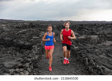 Athletes couple running runners exercising endurance in volcanic landscape extreme terrain. Man runner, Asian woman jogging in activewear sportswear. Fitness exercise workout training for triathlon.