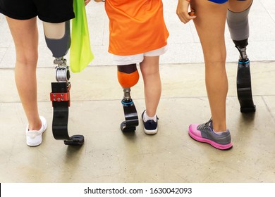 Athletes of different ages with a running leg prosthesis. People with disabilities leading an active lifestyle. The view from the back. Cropped frame. - Powered by Shutterstock