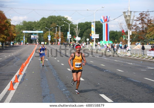 Athletes during the run over the annual Minsk Autumn\
Half Marathon on the road divided by cones.Belarus, Minsk,\
September 2015
