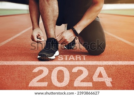 Athletes are getting ready to run on the track with the text  2024 in New Year's Start concept. start the new year 2024 and reach new goals and achievements. planning, challenges, new year resolution.