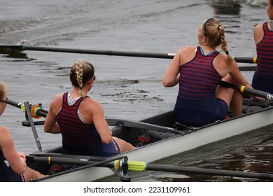 Athletes in the sport of rowing. Female rowing athletes in professional style. They work as a team to win.