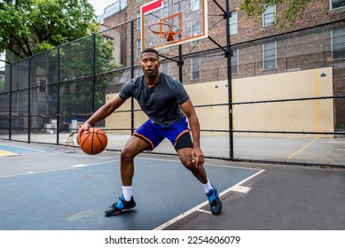 Athletic african american basketball player training on a court in New York - Sportive man playing basket outdoors - Powered by Shutterstock